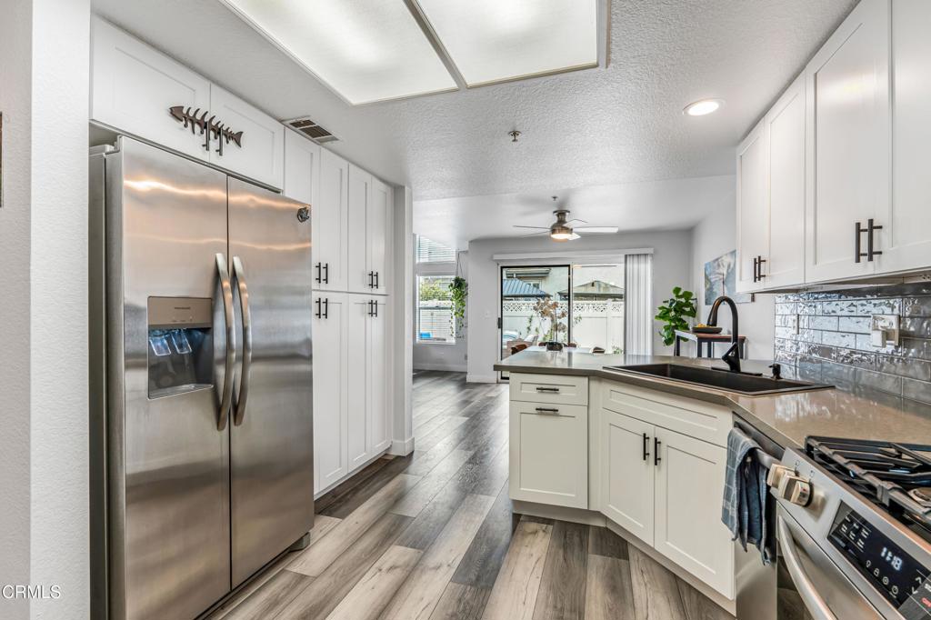 517 Orilla Walk Oxnard, CA 93030 - Photo 11 of 34 a kitchen with stainless steel appliances a refrigerator a sink and white cabinets