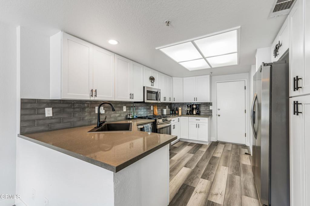 517 Orilla Walk Oxnard, CA 93030 - Photo 9 of 34 a kitchen with white cabinets and stainless steel appliances