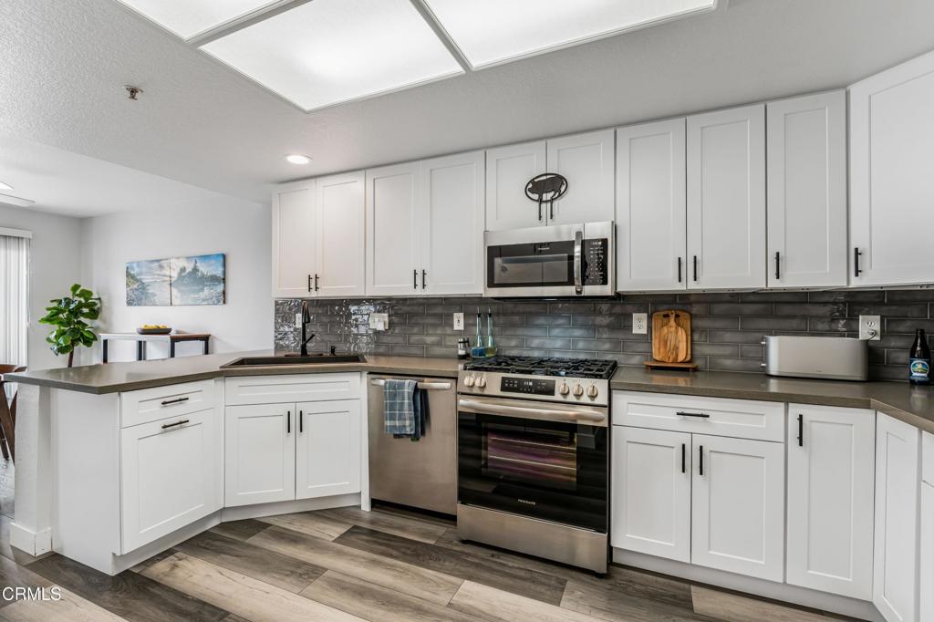 517 Orilla Walk Oxnard, CA 93030 - Photo 10 of 34 a kitchen with stainless steel appliances granite countertop a stove a sink and a microwave