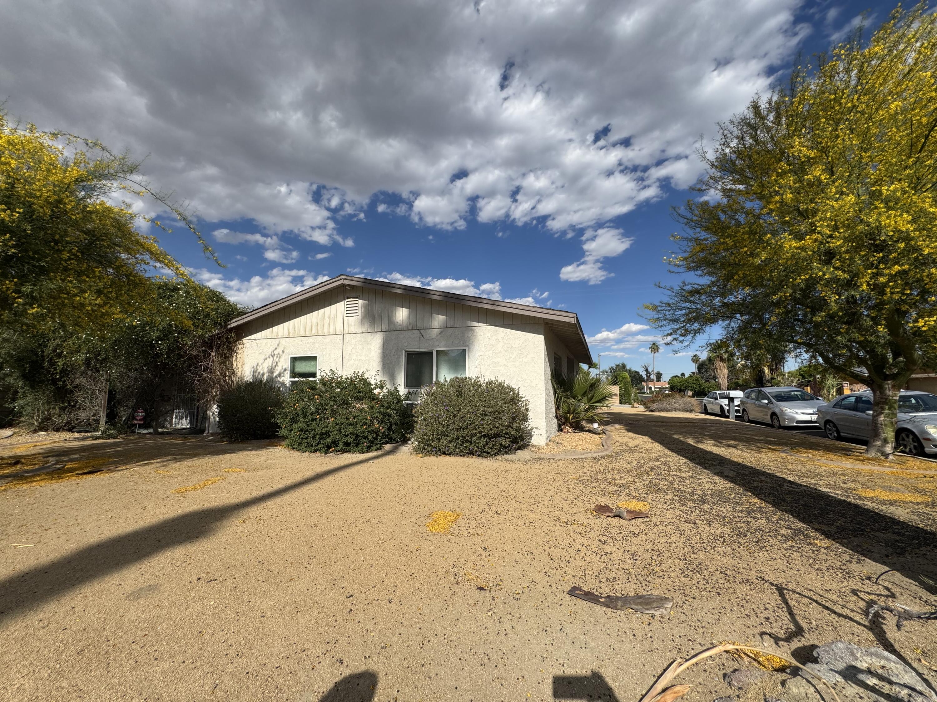 73760 Rancho Road Palm Desert, CA 92260 - Photo 9 of 27 a front view of a house with a yard and garage