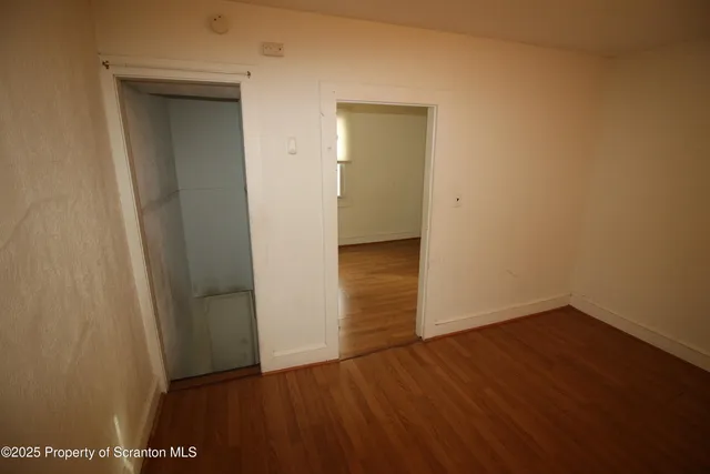 an empty room with wooden floor and closet