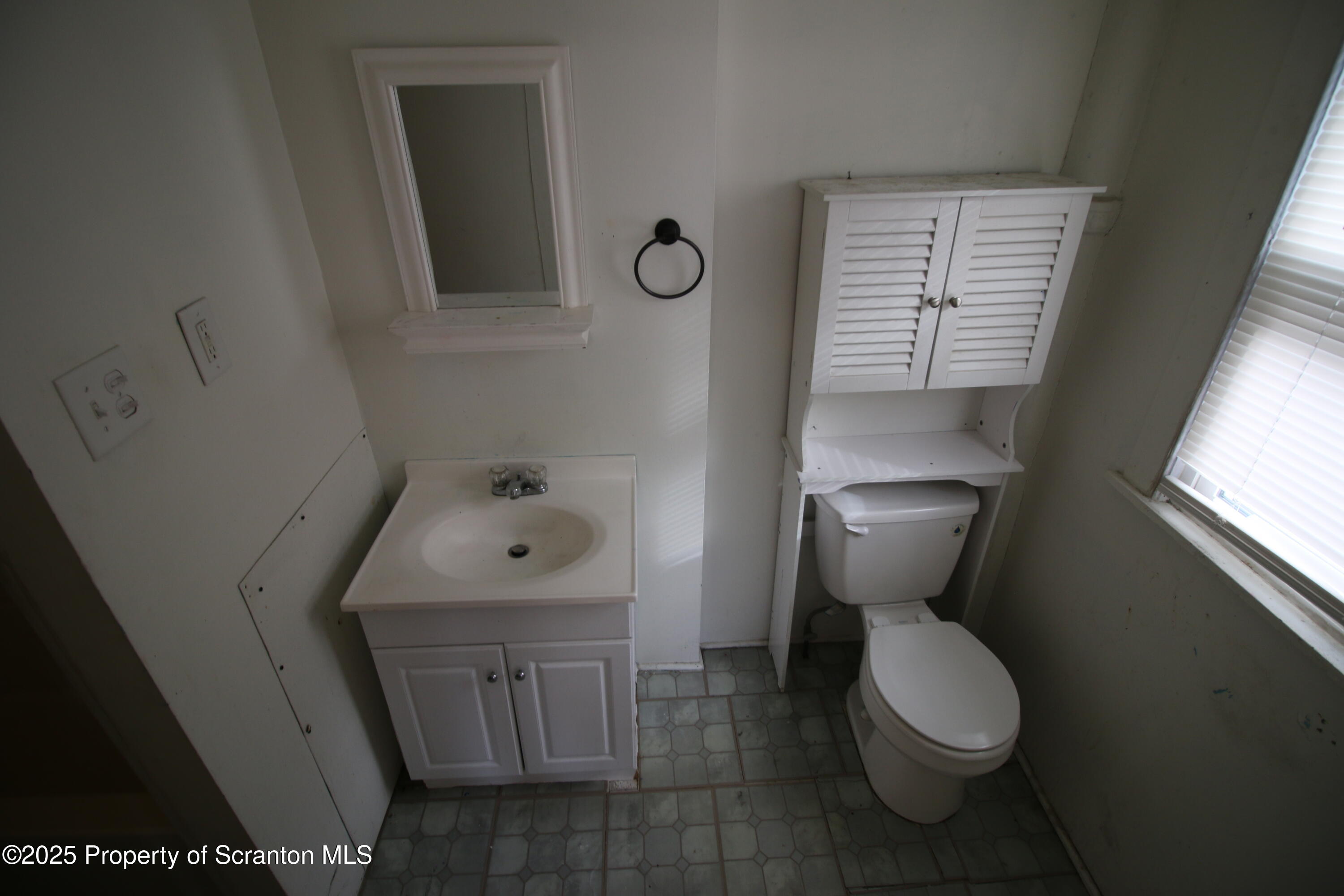 513 Hickory Street Scranton, PA 18505 - Photo 14 of 15 a bathroom with a toilet sink and mirror