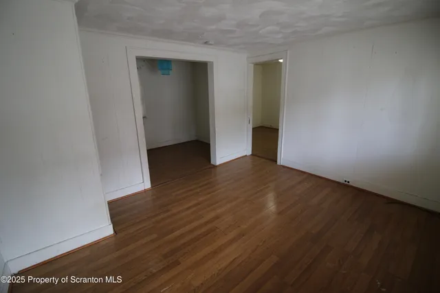an empty room with wooden floor and closet