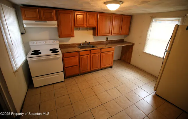 a kitchen with a stove a sink and a refrigerator