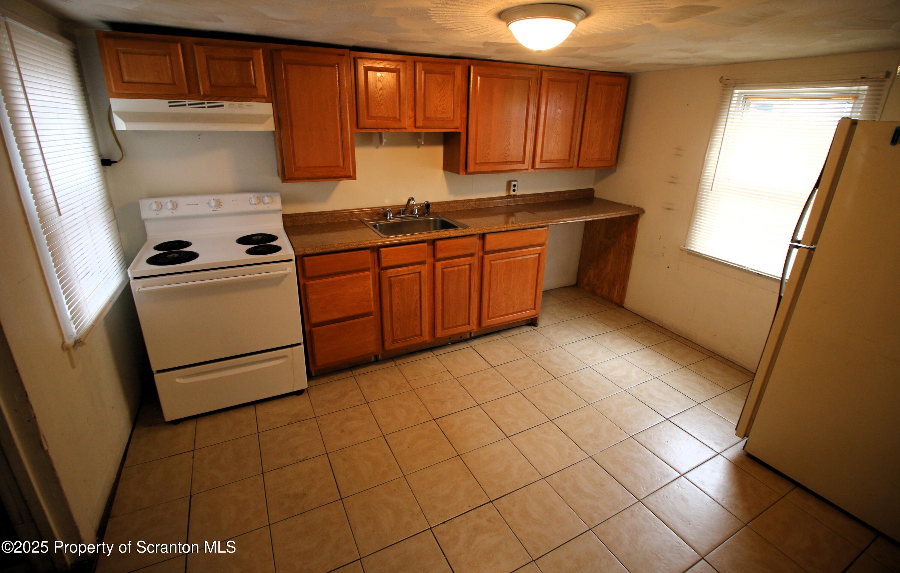 513 Hickory Street Scranton, PA 18505 - Photo 7 of 15 a kitchen with a stove a sink and a refrigerator