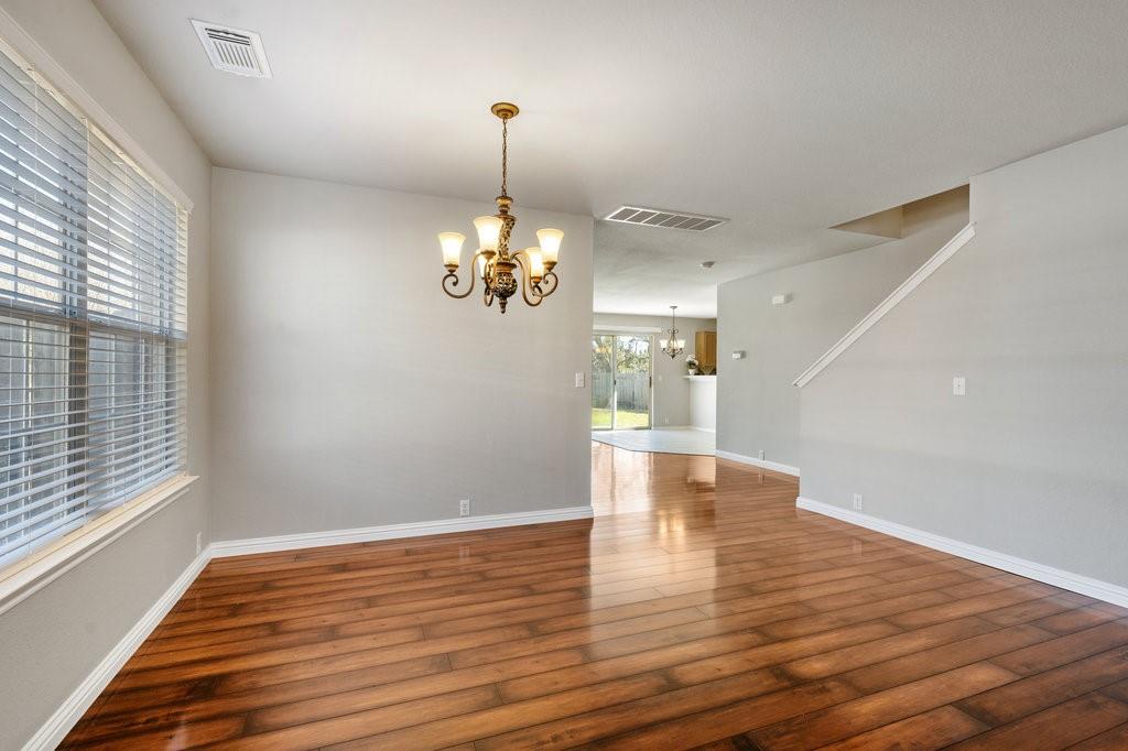 1216 Mathias Street Cedar Park, TX 78613 - Photo 3 of 16 Unfurnished dining area featuring a chandelier and hardwood / wood-style flooring