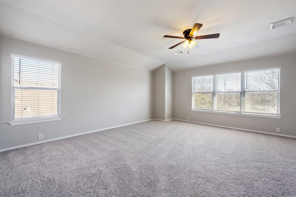 1216 Mathias Street Cedar Park, TX 78613 - Photo 8 of 16 Carpeted spare room featuring healthy amount of natural light, ceiling fan, and vaulted ceiling