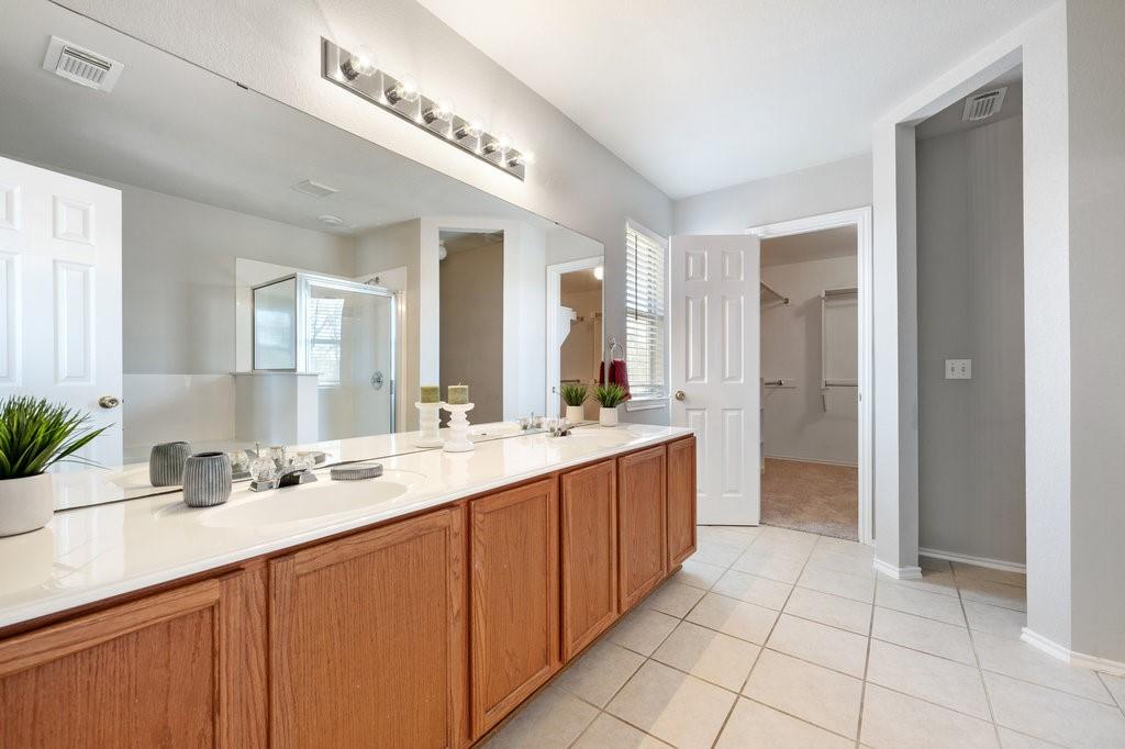 1216 Mathias Street Cedar Park, TX 78613 - Photo 10 of 16 Full bath featuring a spacious closet, a shower stall, double vanity, and light tile patterned floors