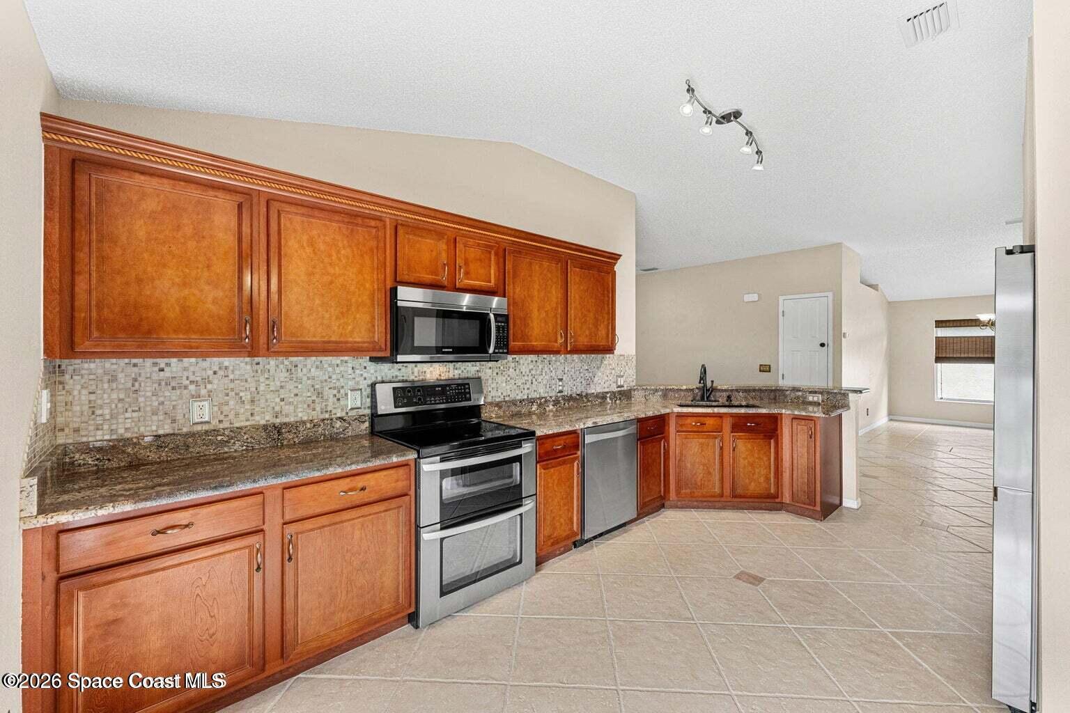 4741 Decatur Circle Melbourne, FL 32934 - Photo 12 of 44 a kitchen with stainless steel appliances granite countertop a stove microwave and sink