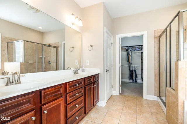 a spacious bedroom with a large bed a chandelier and a potted plant