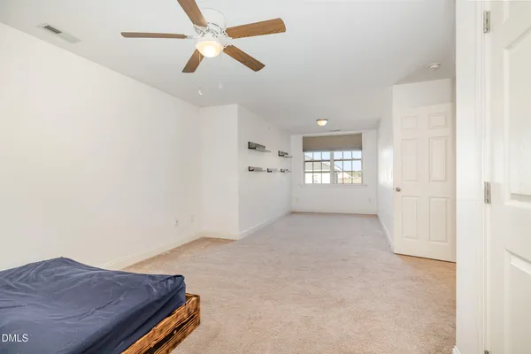 en empty room with windows and ceiling fan