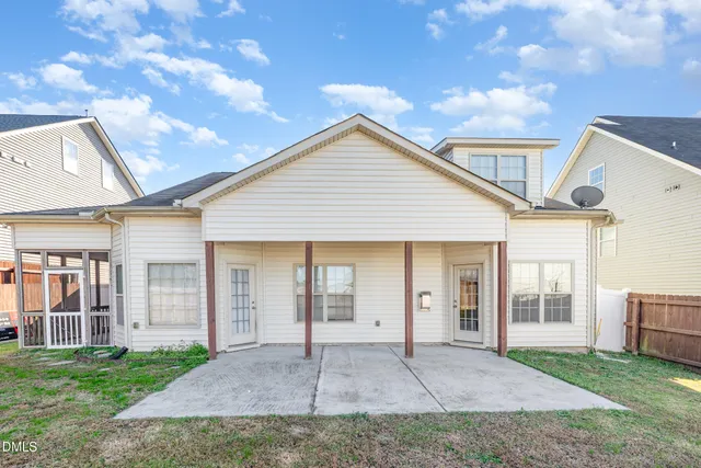 a view of house with backyard and glass door