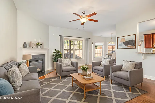 a view of an empty room with a fireplace and wooden floor