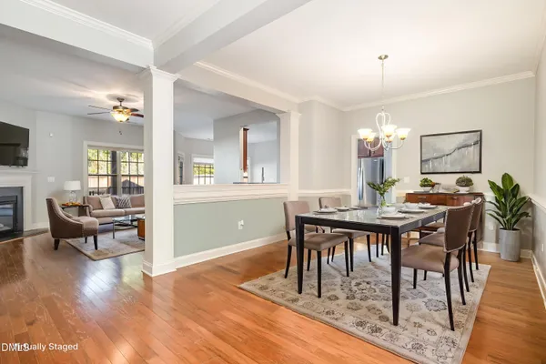 a view of a livingroom with a fireplace wooden floor and chandelier