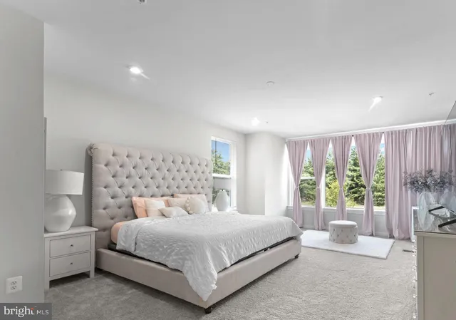 a view of a hallway with a bedroom and wooden floor