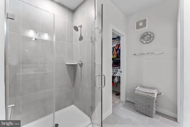 a spacious bathroom with a granite countertop sink a mirror and a shower