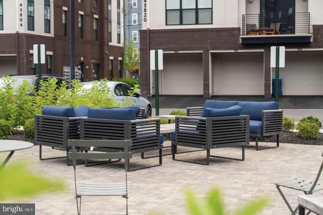 a view of a chairs and a table in the back yard of the building