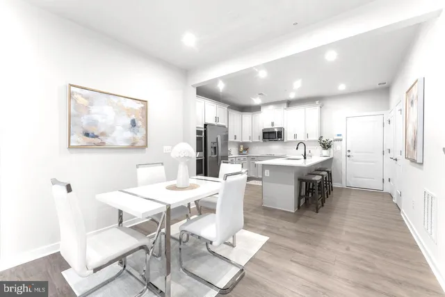 a kitchen with a dining table chairs refrigerator and cabinets