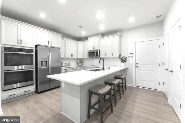 a kitchen with refrigerator cabinets and wooden floor