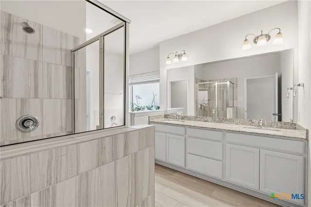 a bathroom with a granite countertop sink a toilet and shower