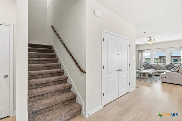 a kitchen with stainless steel appliances granite countertop a sink a stove a refrigerator and island with wooden cabinets