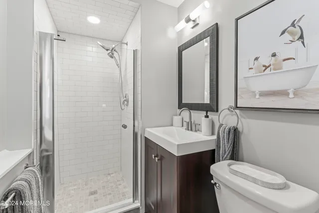 a bathroom with a sink a toilet and shower