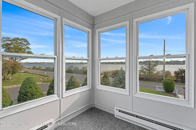 a view of a balcony with wooden chairs and table on the wooden floor