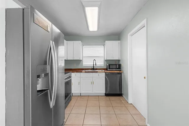 a kitchen with cabinets stainless steel appliances and sink