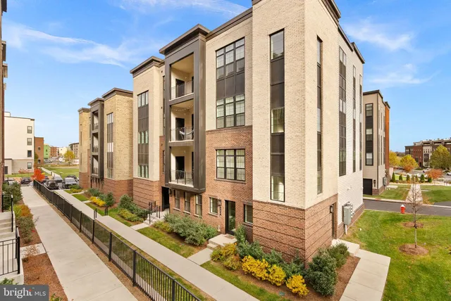a front view of a residential apartment building with a yard