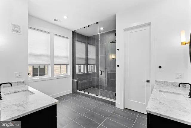 a bathroom with a granite countertop sink a toilet and shower