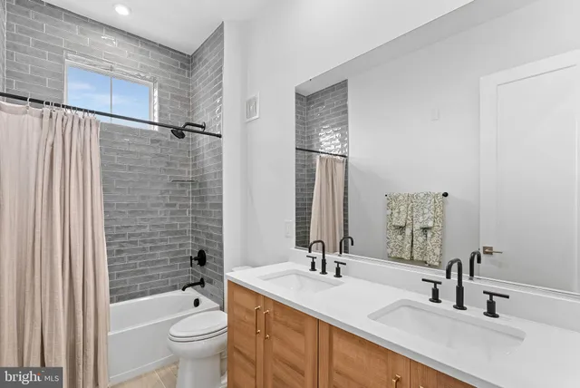 a bathroom with a granite countertop sink a toilet and shower