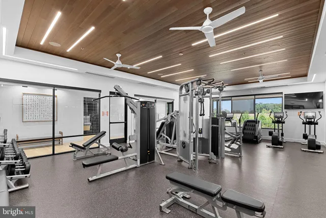 a living room with furniture large window and wooden floor