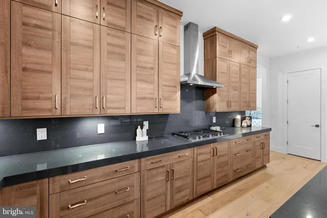 a kitchen with stainless steel appliances granite countertop a sink a stove and cabinets