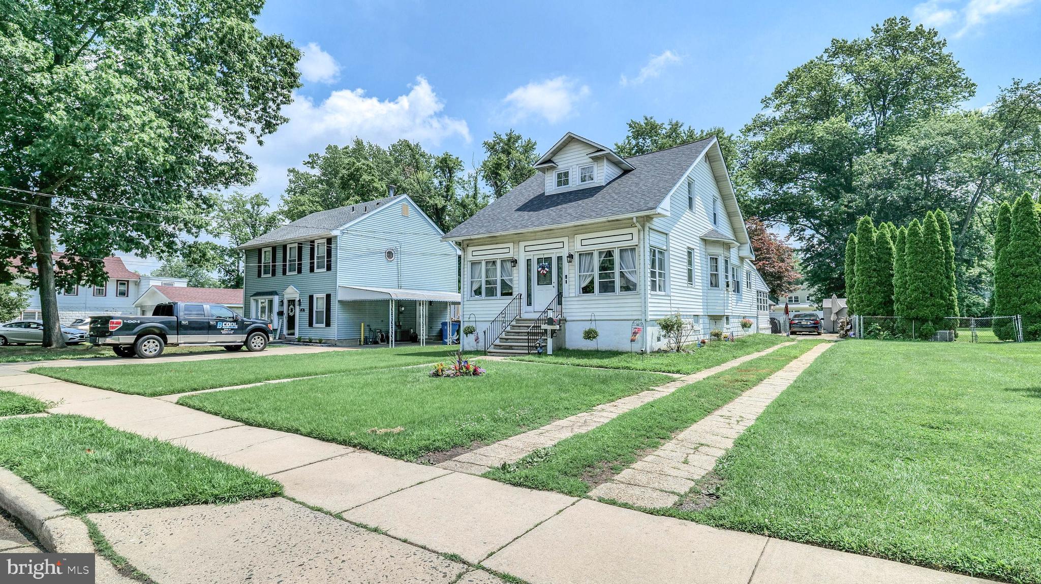 a front view of a house with a yard and trees