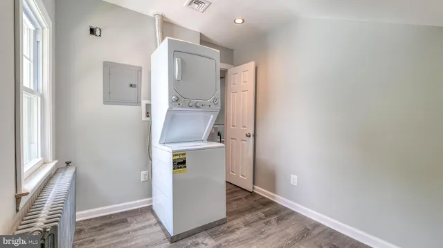 a room with a refrigerator and wooden floor