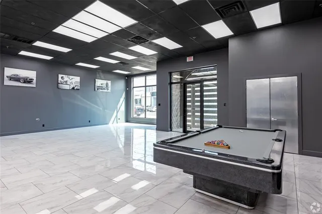 a room with pool table and windows