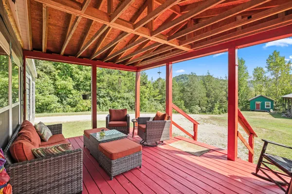a living room with patio furniture and a wooden floor
