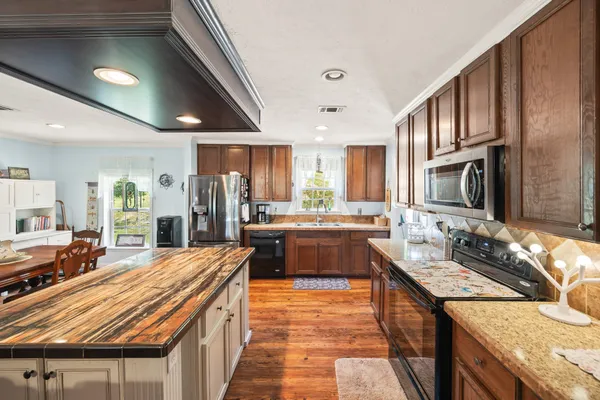 a kitchen with stainless steel appliances granite countertop a refrigerator and a sink