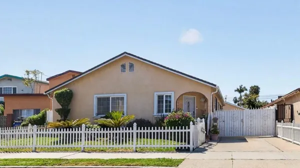 a front view of a house with a yard and potted plants