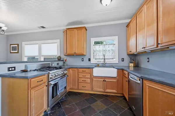 a kitchen with stainless steel appliances granite countertop a sink stove and cabinets