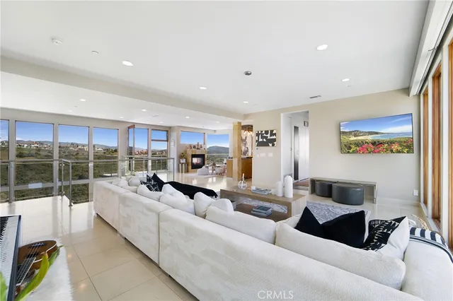 a living room with furniture kitchen view and a large window