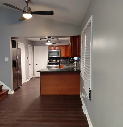 a kitchen with stainless steel appliances a refrigerator and a stove top oven