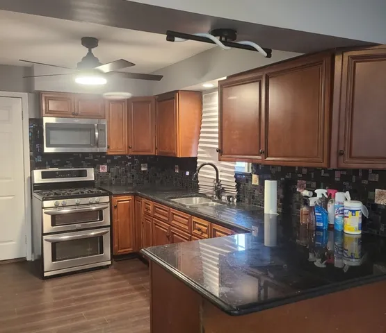 a kitchen with stainless steel appliances granite countertop a sink stove and cabinets