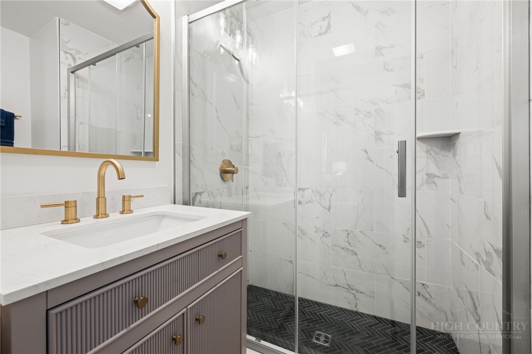 811 Pine Ridge Road Beech Mountain, NC 28604 - Photo 13 of 26 a bathroom with a sink a vanity and a shower
