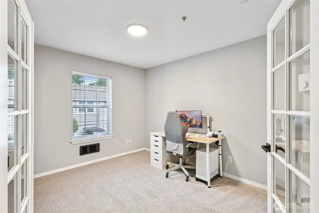 a view of a workspace with furniture and a window