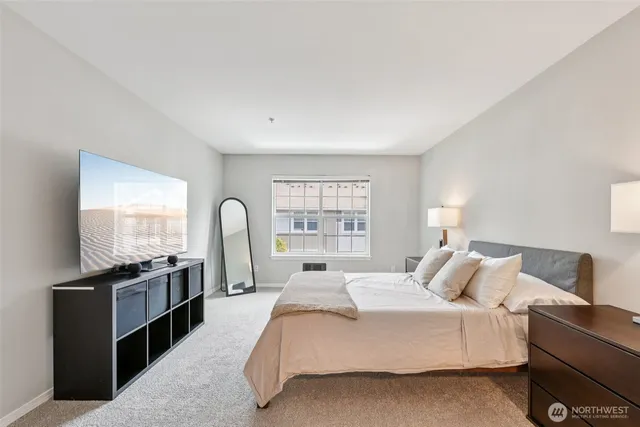 a spacious bedroom with a bed and a large window