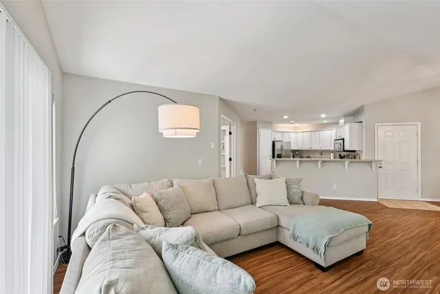 a living room with furniture and a large mirror with wooden floor