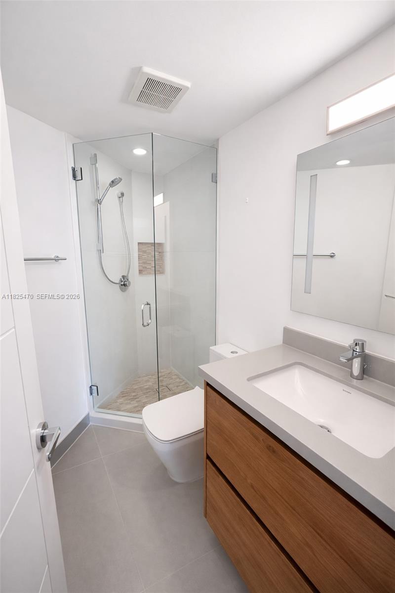 520 Brickell Key Drive, Unit A1421 Miami, FL 33131 - Photo 13 of 16 a bathroom with a granite countertop sink a toilet and shower