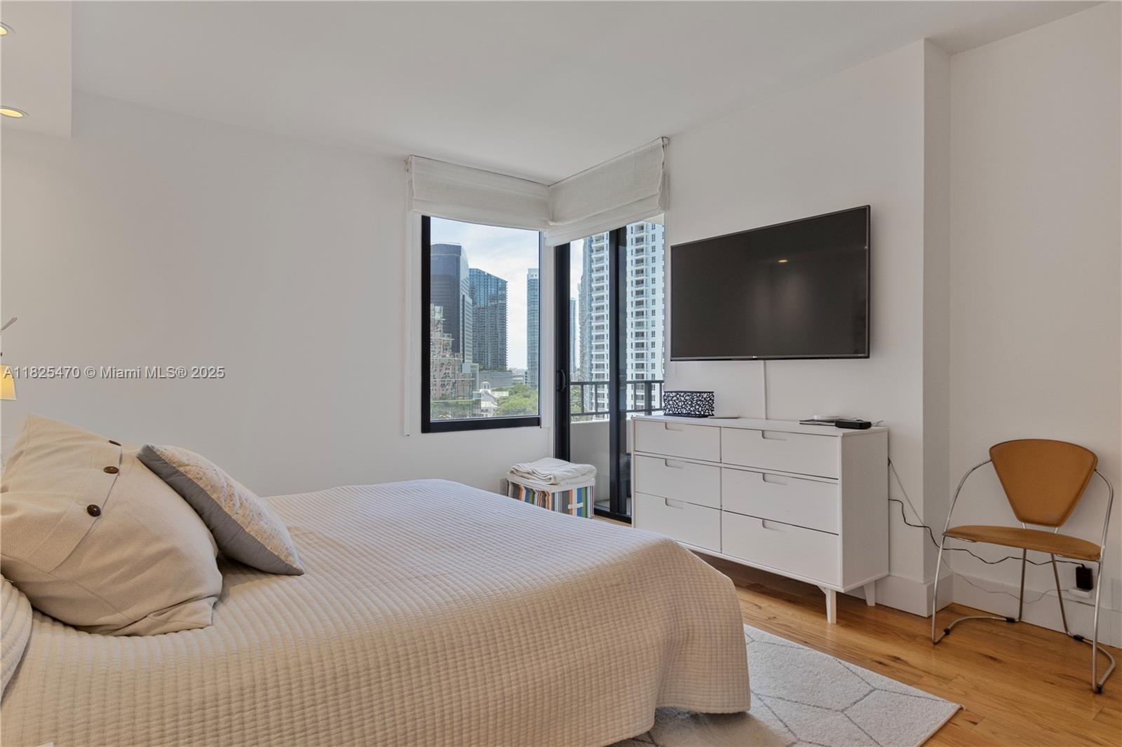 520 Brickell Key Drive, Unit A1421 Miami, FL 33131 - Photo 15 of 34 a bedroom with a bed and a flat screen tv