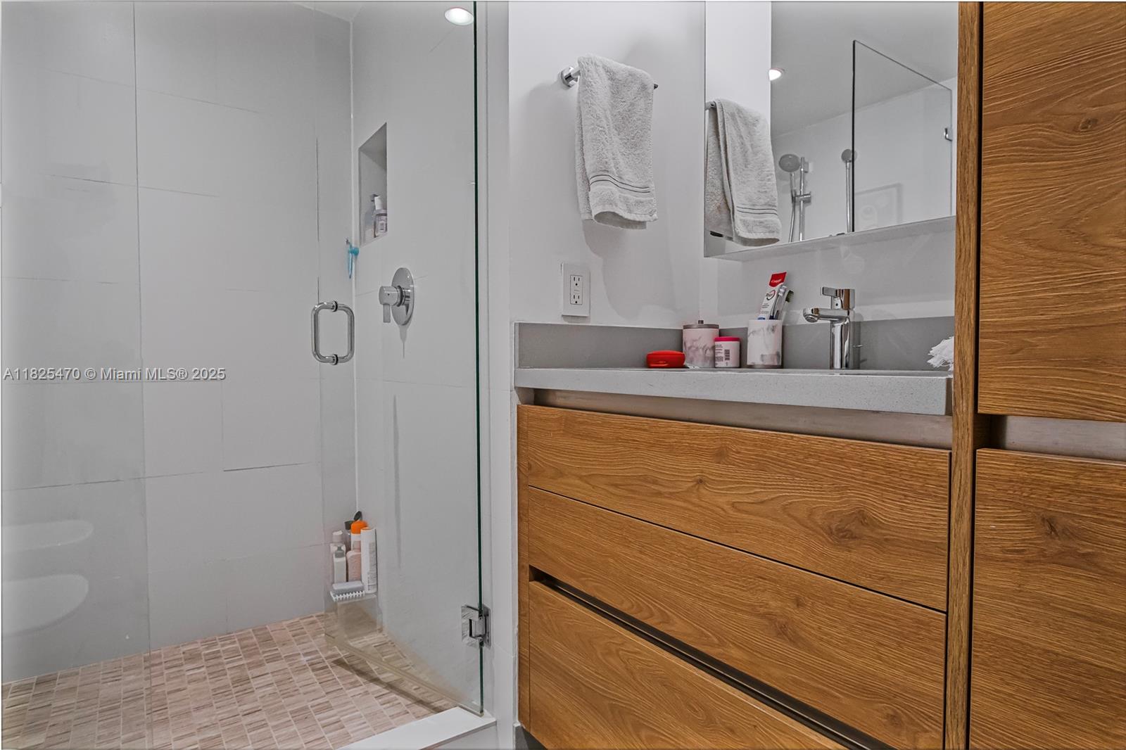 520 Brickell Key Drive, Unit A1421 Miami, FL 33131 - Photo 22 of 34 a bathroom with a sink vanity and shower